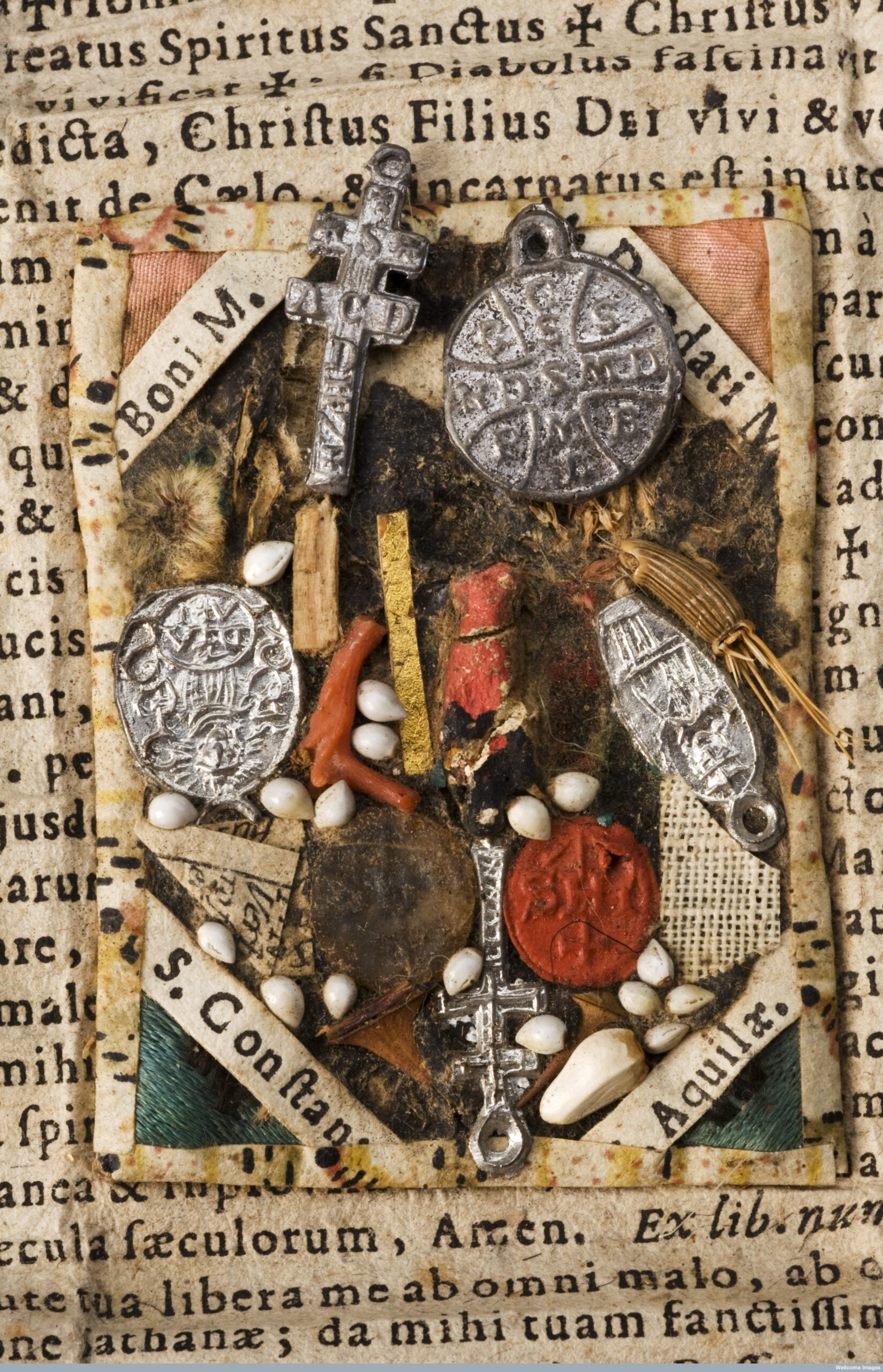 L0059002 Amulet and charm to protect against plague, printed Latin chCredit: Science Museum, London. Wellcome Imagesimages@wellcome.ac.ukhttp://wellcomeimages.orgAmulet and charm to protect against plague, printed Latin charm on which is pasted rectangular composite amulet with 4 metal pendants affixed, all backed with patterned paper and folded into rectangular packet, Bavaria, German, 1690-1710. Detail of central section - metal pendants.Published: - Copyrighted work available under Creative Commons Attribution only licence CC BY 4.0 http://creativecommons.org/licenses/by/4.0/